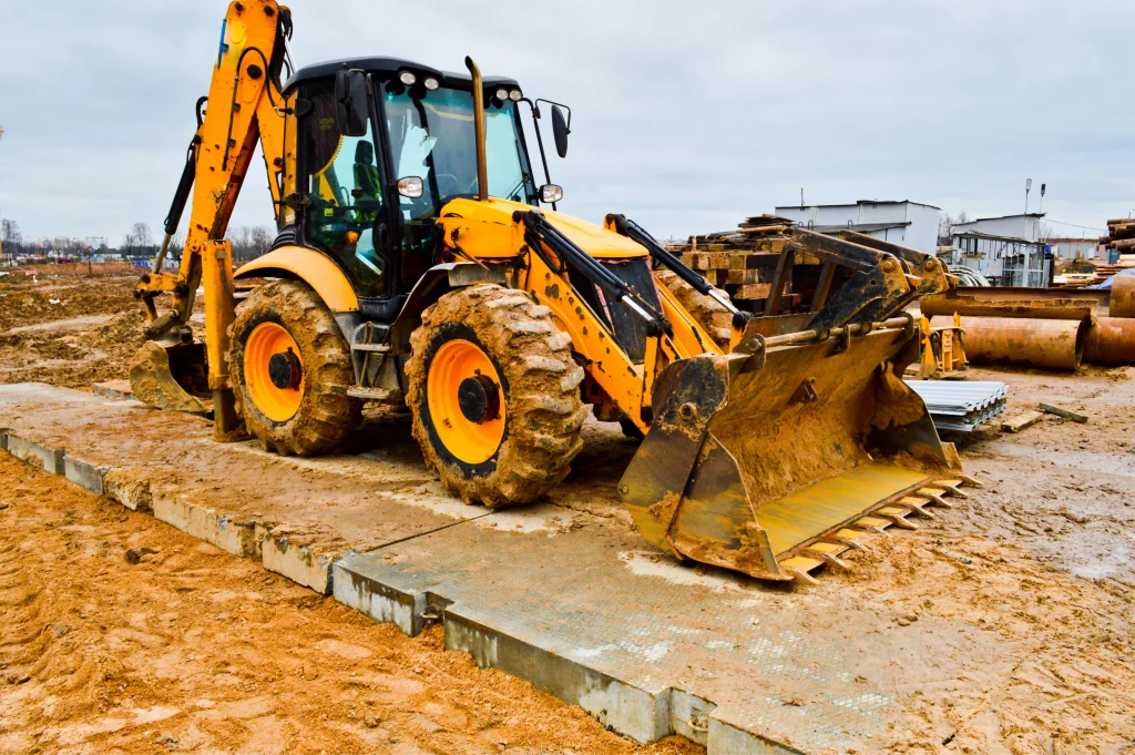 big bright yellow powerful industrial heavy excavator tractor bulldozer specialized construction equipment for road repair during the construction of a new micro district in a big city photo 1